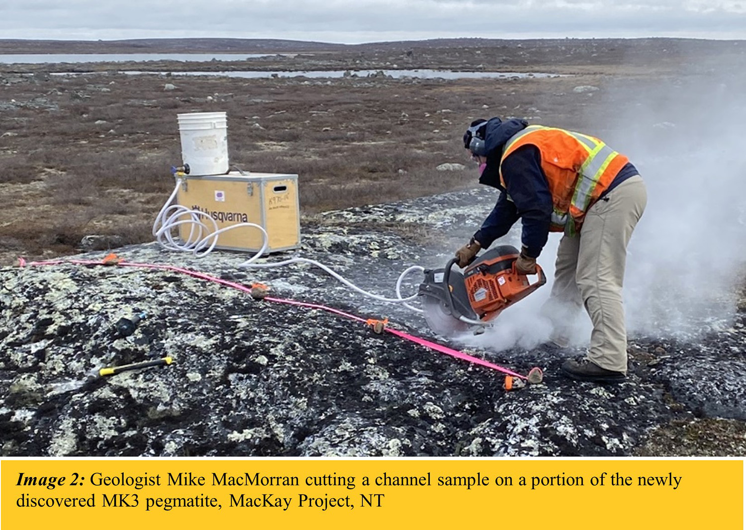 Geologist Mike MacMorran cutting a channel sample on a portion of the newly discovered MK3 pegmatite, MacKay Project, NT